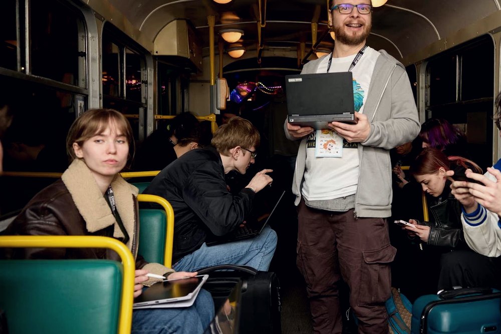 Uczestnik stojący w tramwaju z laptopem w rękach