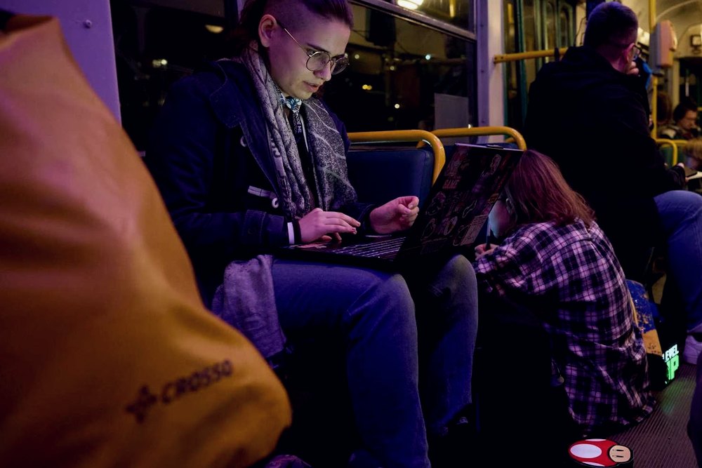 Uczestniczka programująca na laptopie w jadącym tramwaju