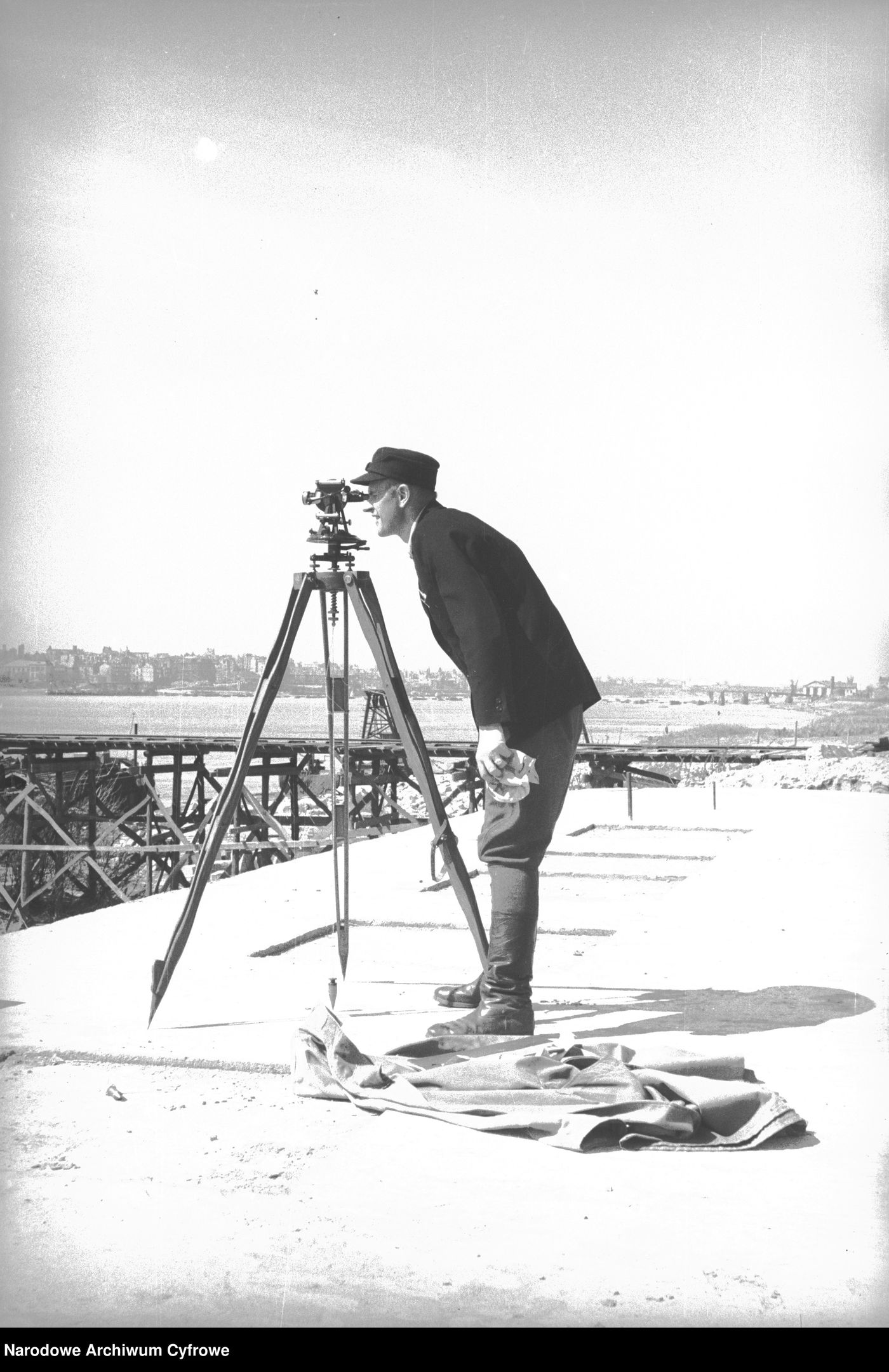 Geodeta przy teodolicie — fotografia archiwalna ze zbiorów Narodowego Archiwum Cyfrowego